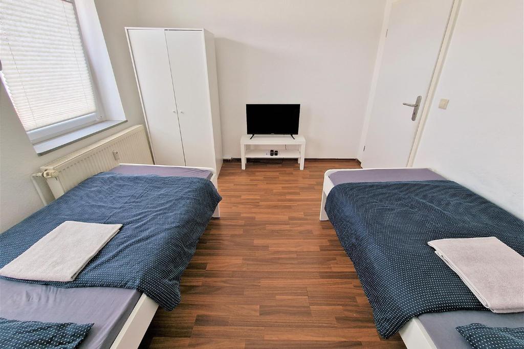 two beds in a small room with a tv at Apartment with Roof-Top in Düren in Düren - Eifel