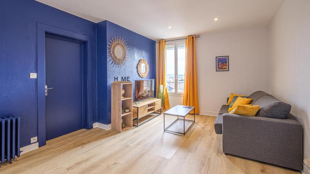 un salon avec un canapé et un mur bleu dans l'établissement Bleu Nuit - Welc'Home, à Limoges