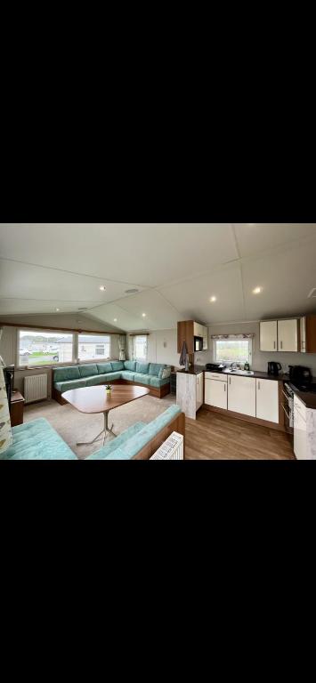 a large kitchen with a couch and a table at Tarka Holiday Park in Ashford