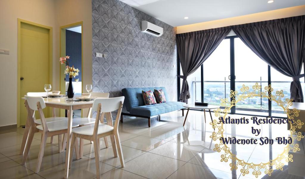 un soggiorno con tavolo e divano blu di Atlantis Residence - Widenote Sdn Bhd a Malacca