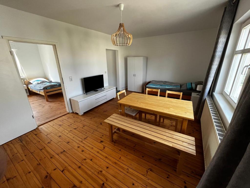 a living room with a wooden table and a television at Große Monteurwohunung-Fewo in Trebbin