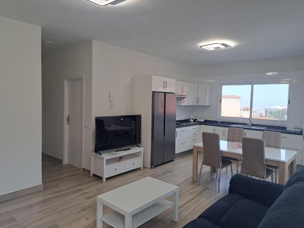 una cucina e un soggiorno con un tavolo e un divano di La Casa de Amalia a San Pedro de Daute