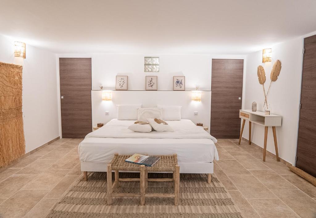 ein weißes Schlafzimmer mit einem Bett und einem Tisch in der Unterkunft Location de chambre Villa les allamandas in Mandelieu-la-Napoule