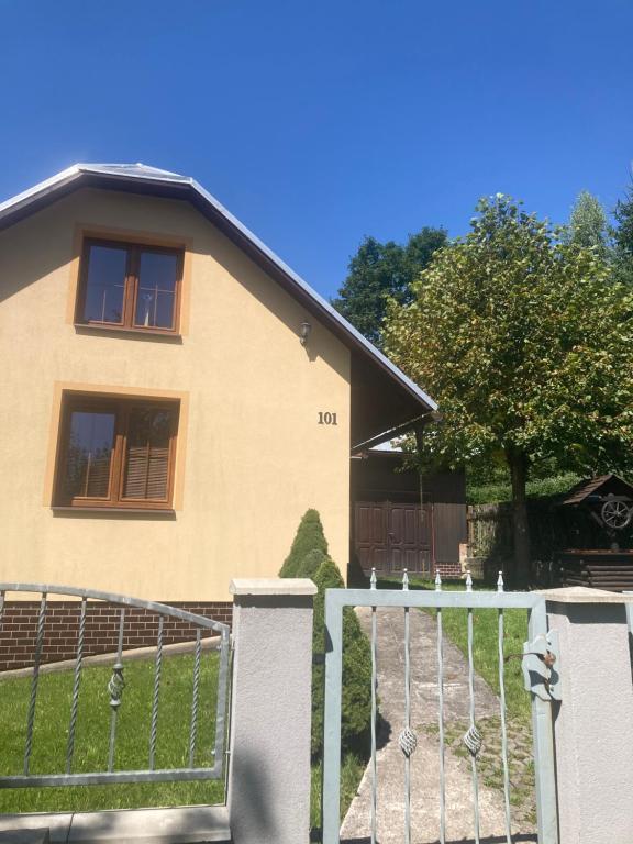 ein Haus mit einem Tor davor in der Unterkunft Chalúpka Mischel in Raková