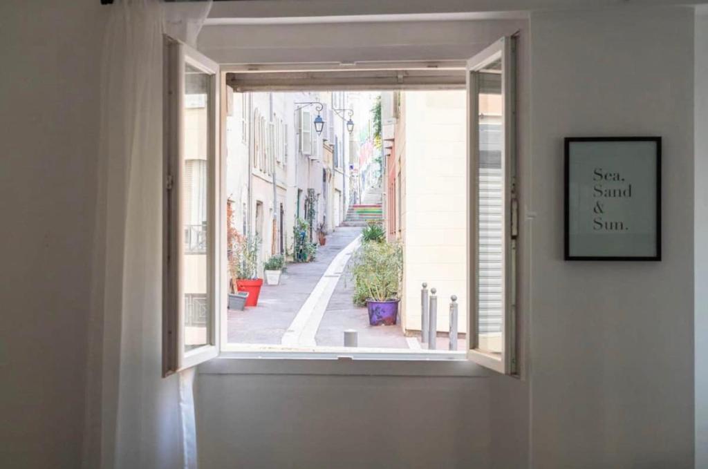una ventana en una pared con vistas a la calle en Les 6 Phocéens, en Marsella
