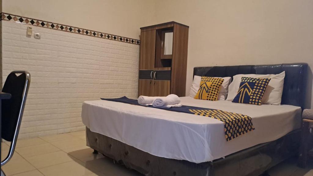 um quarto com uma cama grande e toalhas em Bintang Khanida Syari'ah em Tjakranegara