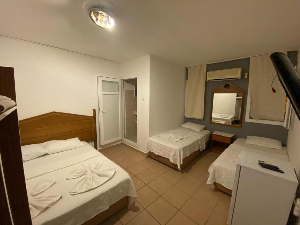Habitación de hotel con 2 camas y espejo en DENGE PANSİYON, en Datça