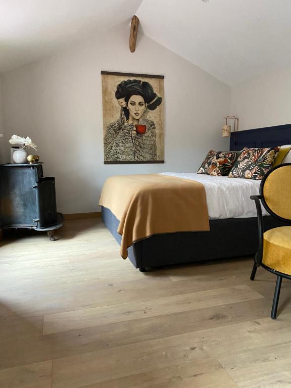 - une chambre avec un lit et une peinture d'une femme dans l'établissement L'ATELIER 14 - Centre ville - Appartement entier- Neuf, à Chartres