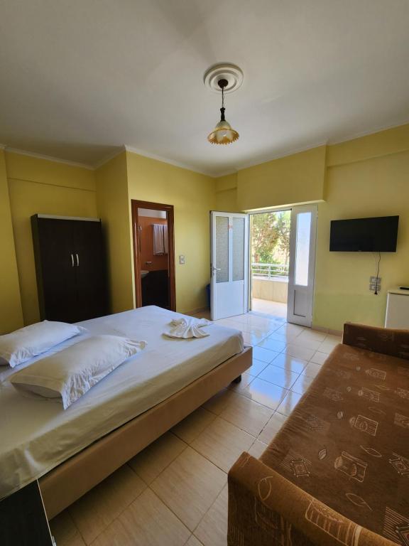 1 dormitorio con 1 cama grande y TV en Amelia Apartments en Ksamil