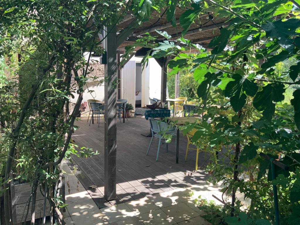 une terrasse avec des chaises, une table et des arbres dans l'établissement GinKgo, à Marseille