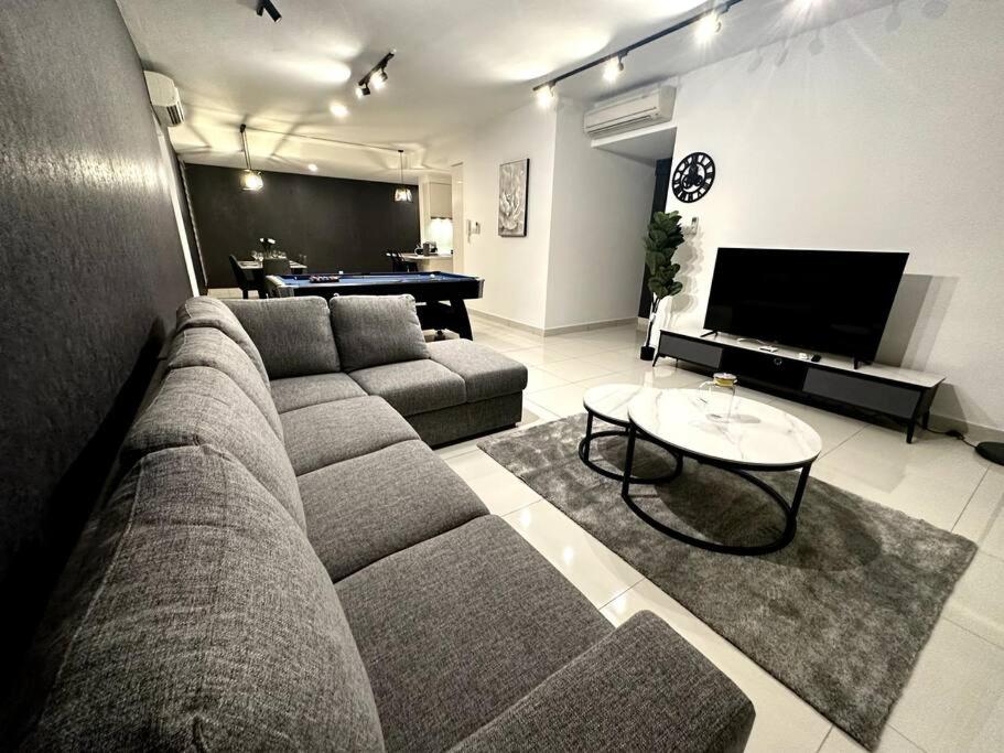 sala de estar con sofá y mesa en Teega Modern 4BR 12pax pooltable by Our Stay en Nusajaya