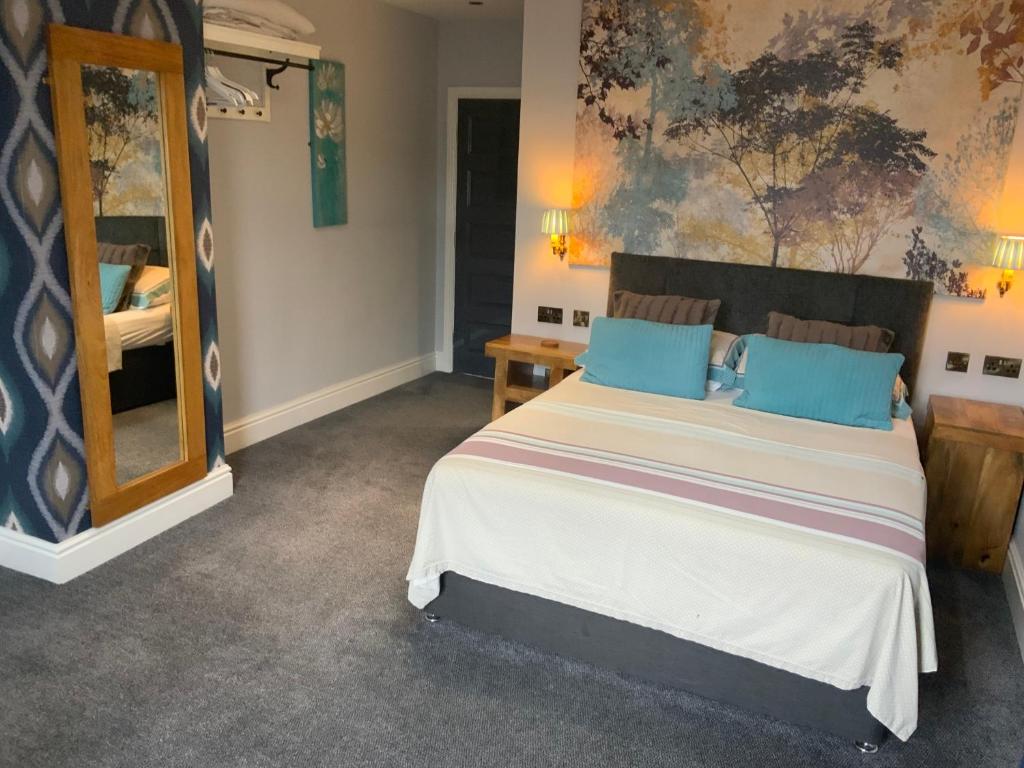 a bedroom with a large bed and a mirror at Wheldale Hotel in Castleford