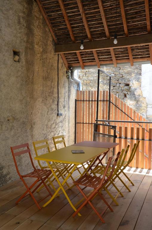 a yellow table and chairs in a room at les gîtes du passage: le perchoir in Passenans