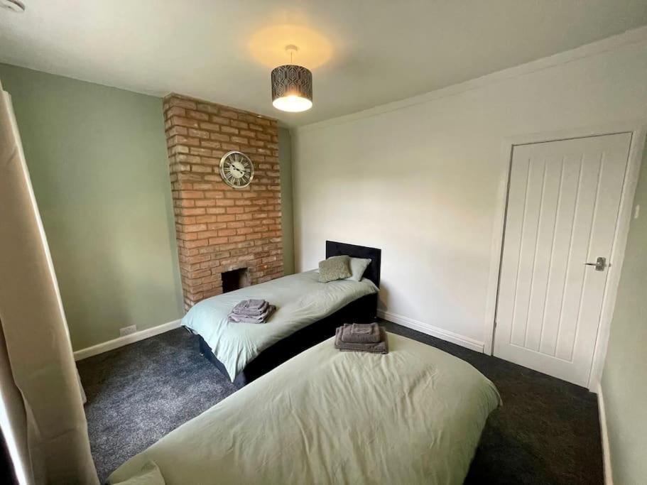 a room with two beds and a brick wall at House near city centre in Hull