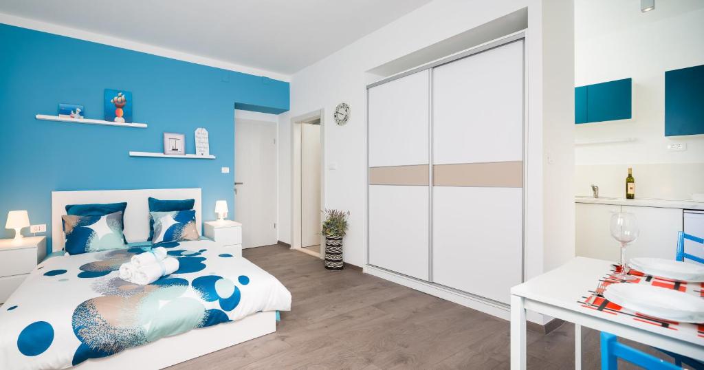 Split Dreams Apartments في سبليت: غرفة نوم بجدران زرقاء وسرير مع مكتب