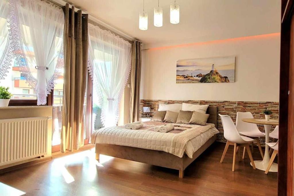 1 dormitorio con 1 cama, mesa y sillas en Modern Apartment SANDY BEACH down town, aquapark, free parking, en Cracovia