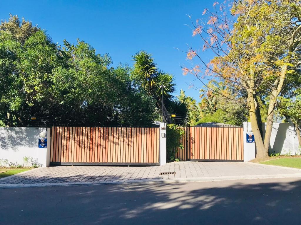 a wooden gate on a street with a fence at 10VDW Self Catering Apartments in Durbanville