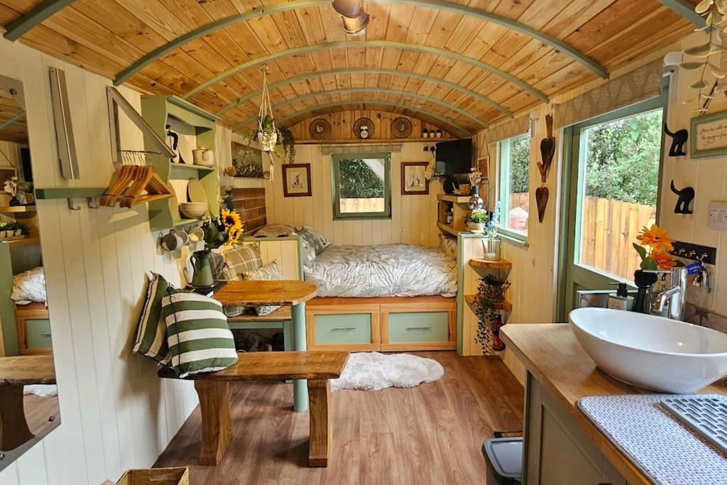 a tiny house with a sink and a bedroom at Cobblers Cabin in Dallington