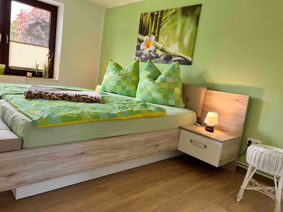 1 dormitorio con 1 cama grande y paredes verdes en FeWo Ostsee Oase - gemütlich, ländlich, WLAN en Marlow