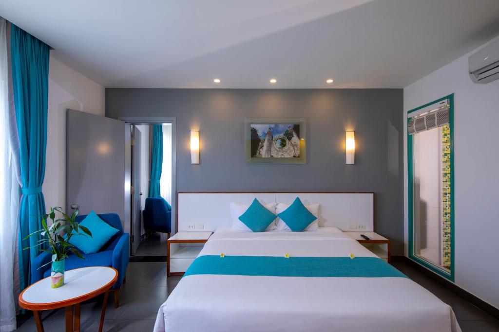 Postel nebo postele na pokoji v ubytování ÊMM Hotel Hoi An
