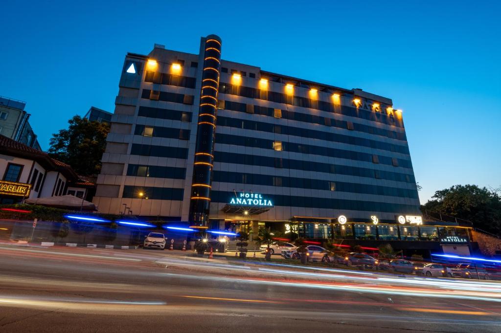 a tall building with lights in front of a street at Hotel Anatolia in Bursa