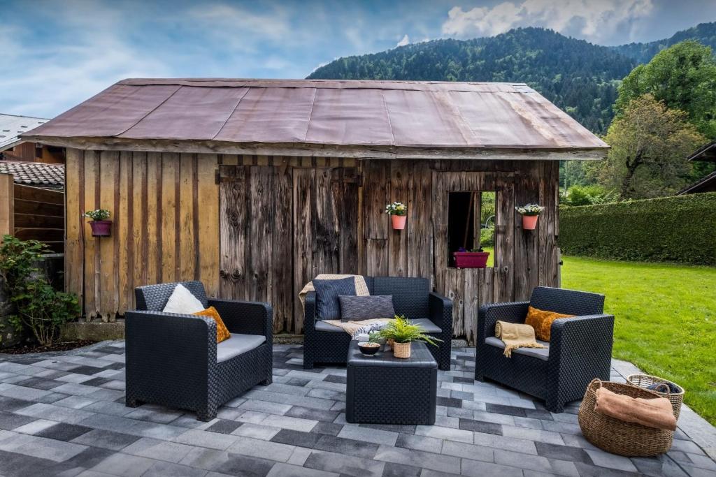 a backyard patio with chairs and a shed at Chalet 65bis - OVO Network in Thônes