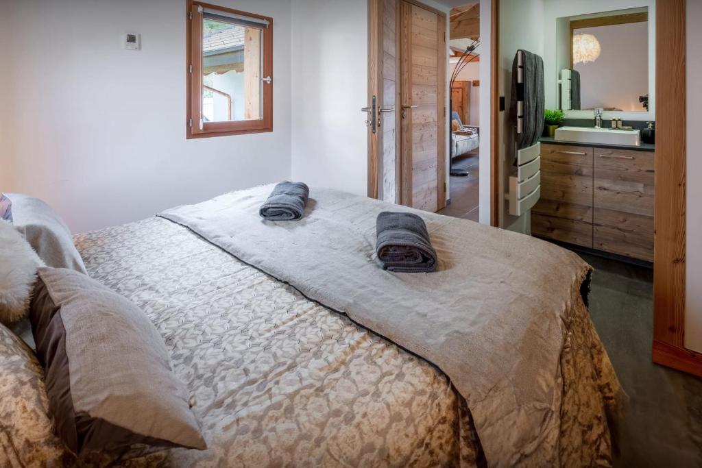 a bedroom with a bed with two towels on it at Chalet 65bis - OVO Network in Thônes