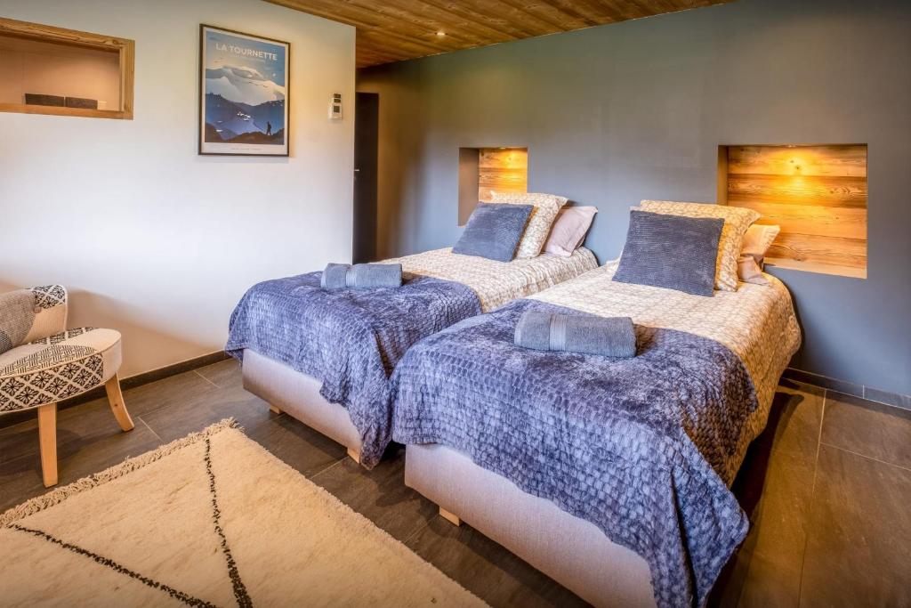 a bedroom with three beds with blue comforters at Chalet 65bis - OVO Network in Thônes