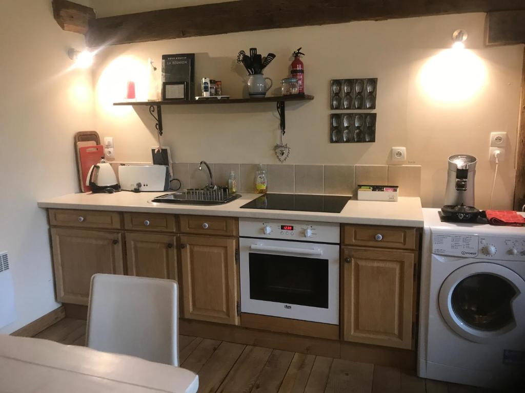 a kitchen with a sink and a washing machine at La Merise Gite in Villefranche-dʼAlbigeois