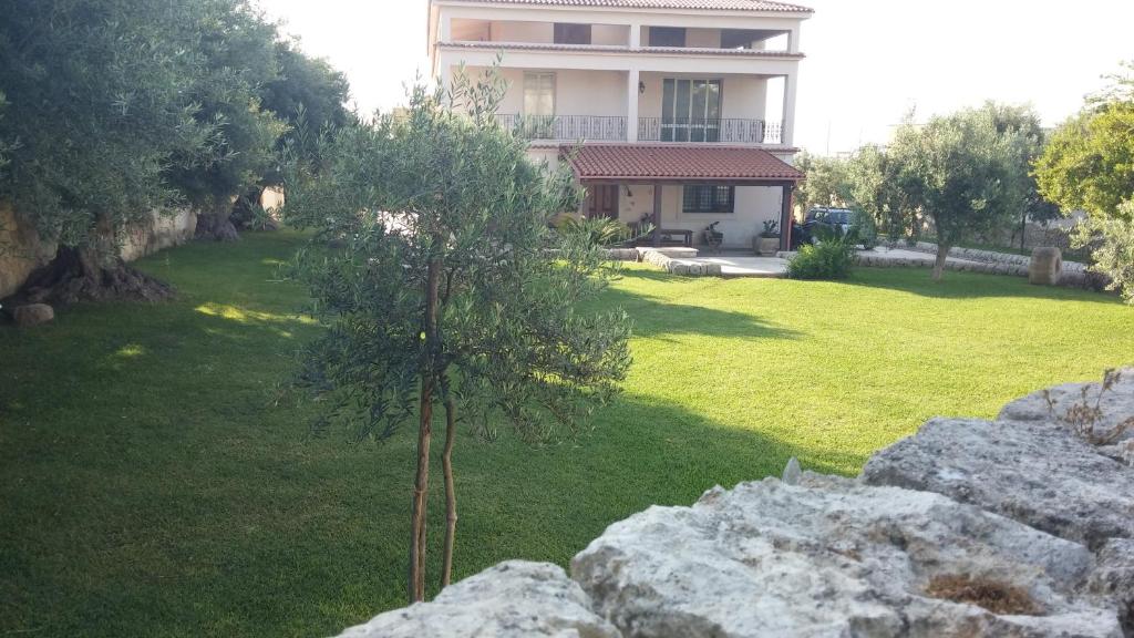 uma pequena árvore num quintal ao lado de um edifício em Casa Vista Mare em Avola