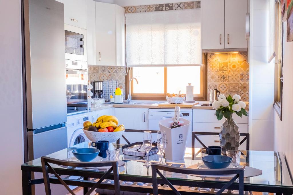 a kitchen with a table with a bowl of fruit at ViVaTenerife - Cosy and elegant flat in Los Abrigos in Los Abrigos