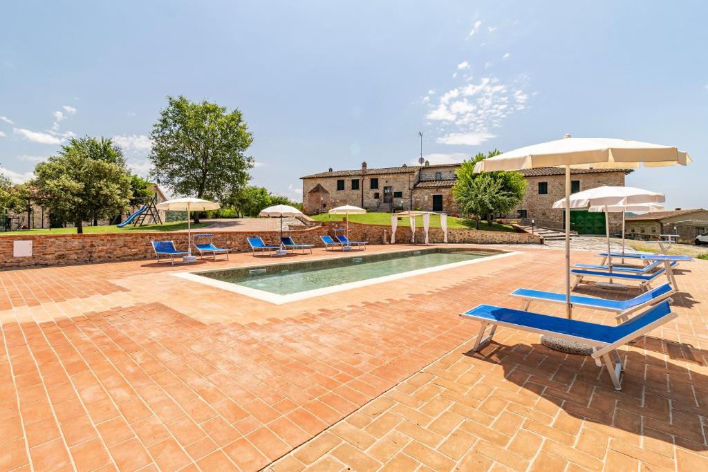 einen Pool mit blauen Stühlen und Sonnenschirmen in der Unterkunft Villa Santarcangelo With Pool - Happy Rentals in Asciano