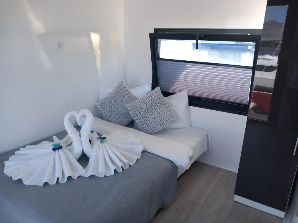 1 dormitorio con 1 cama con sábanas blancas y ventana en Hausboat David, en Hrdoňov