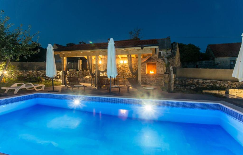 a swimming pool in front of a house at night at Villa Lucia in Vukići
