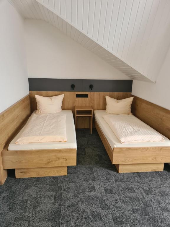 two twin beds in a room with a attic at Gästehaus Weber in Rodgau