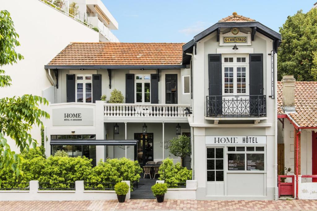 una casa con un cartel de encuentro en la parte delantera en Hotel Home Arcachon, en Arcachon