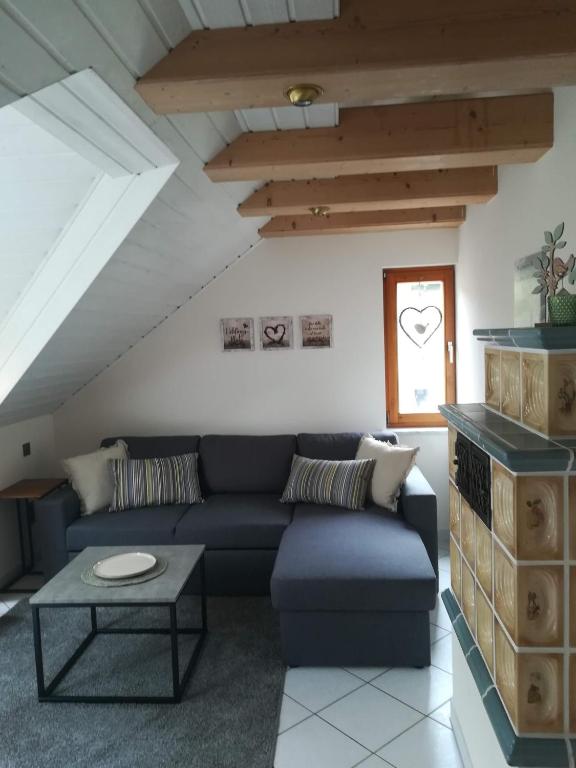 a living room with a blue couch and a table at Ferienwohnung Hopfengärtner in Hiltpoltstein