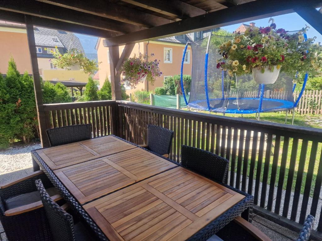een houten tafel en stoelen op een balkon met een prieel bij Apartment Emma in Liezen