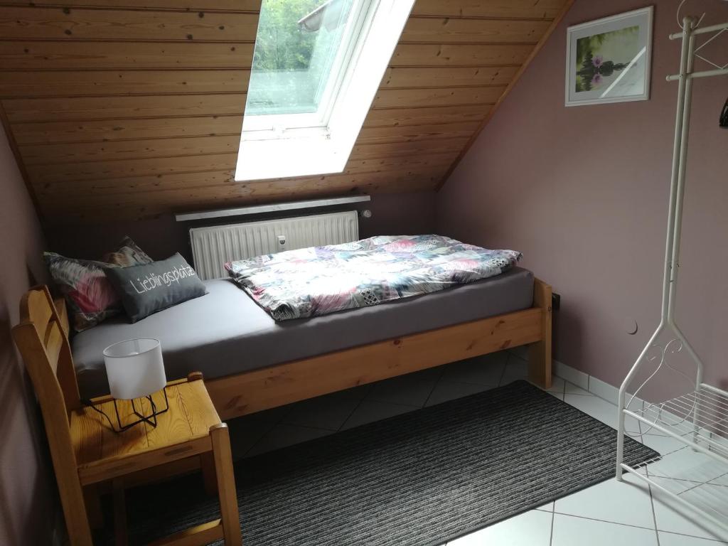 a bed in a small room with a window at Ferienwohnung Hopfengärtner in Hiltpoltstein