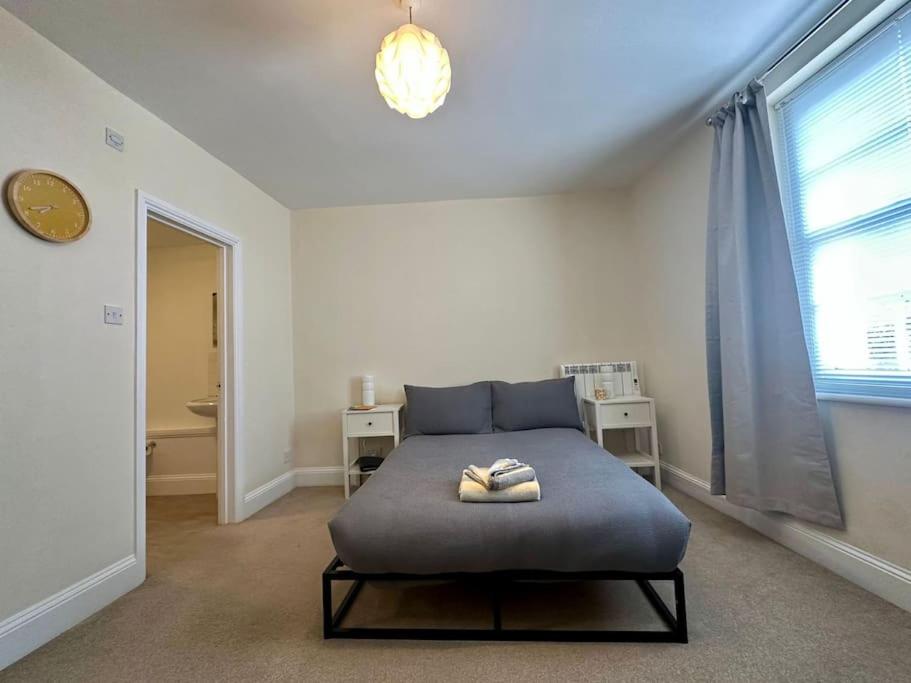 um quarto com uma cama e uma grande janela em Studio apartment, The Suffolks. em Cheltenham