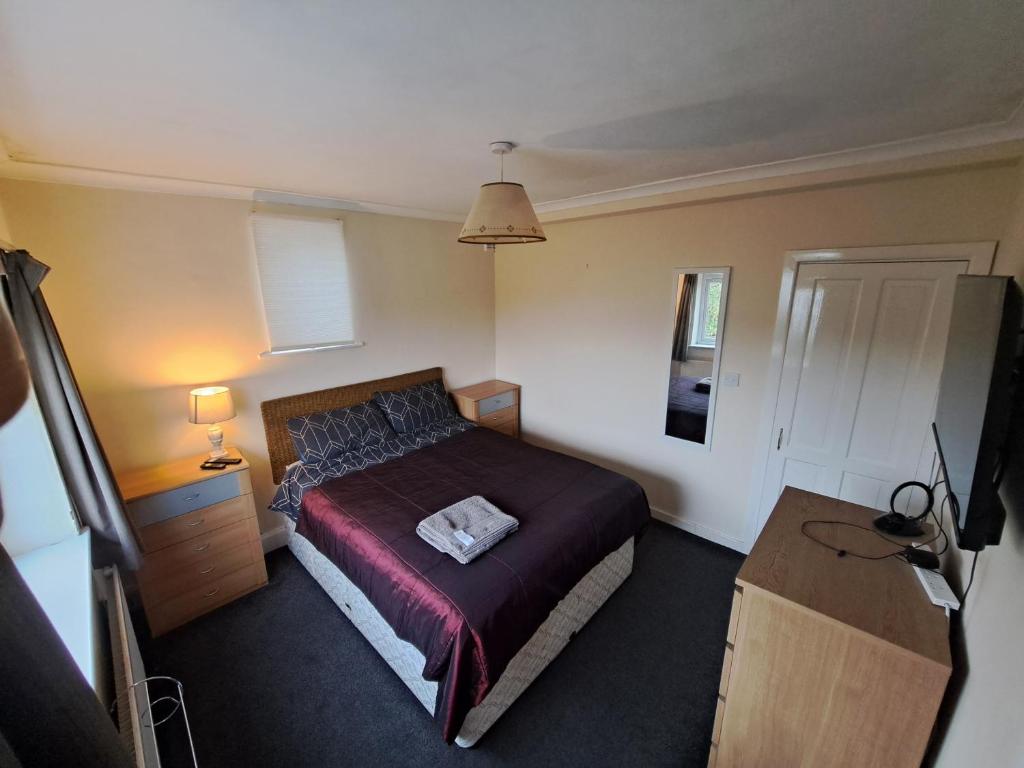 a small bedroom with a bed and a table at Woodard House in Woodchurch