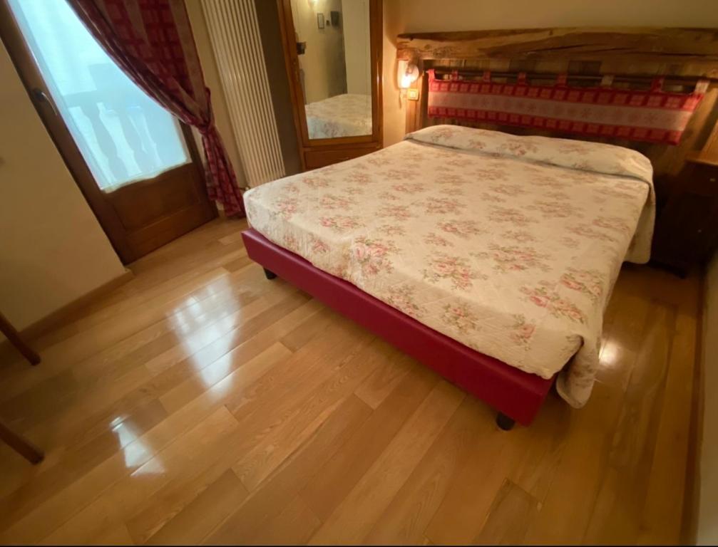 uma pequena cama num quarto com piso em madeira em Chambres D'Hotes de Montagne em Pré-Saint-Didier