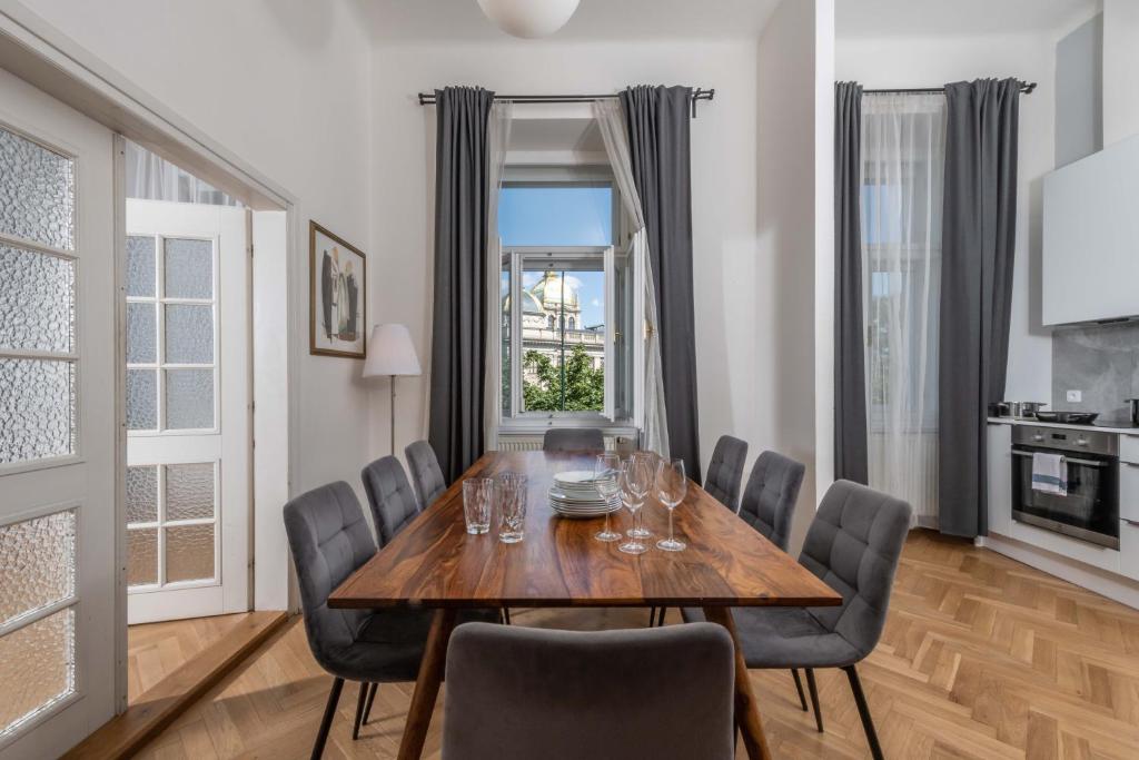 uma sala de jantar com uma mesa de madeira e cadeiras em Centrally located 3BD home near National Museum em Praga