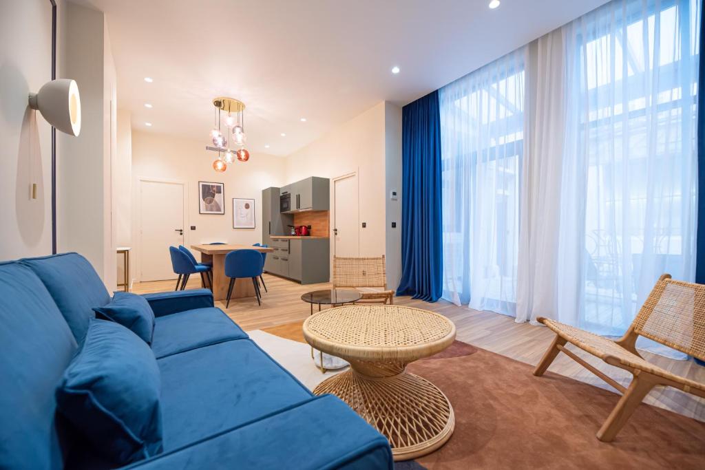 een woonkamer met een blauwe bank en een tafel bij Loft in canal saint martin in Parijs