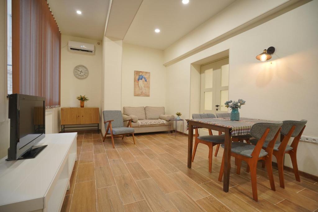 a living room with a table and chairs and a television at New Apartment Near Holiday Inn in Tbilisi City