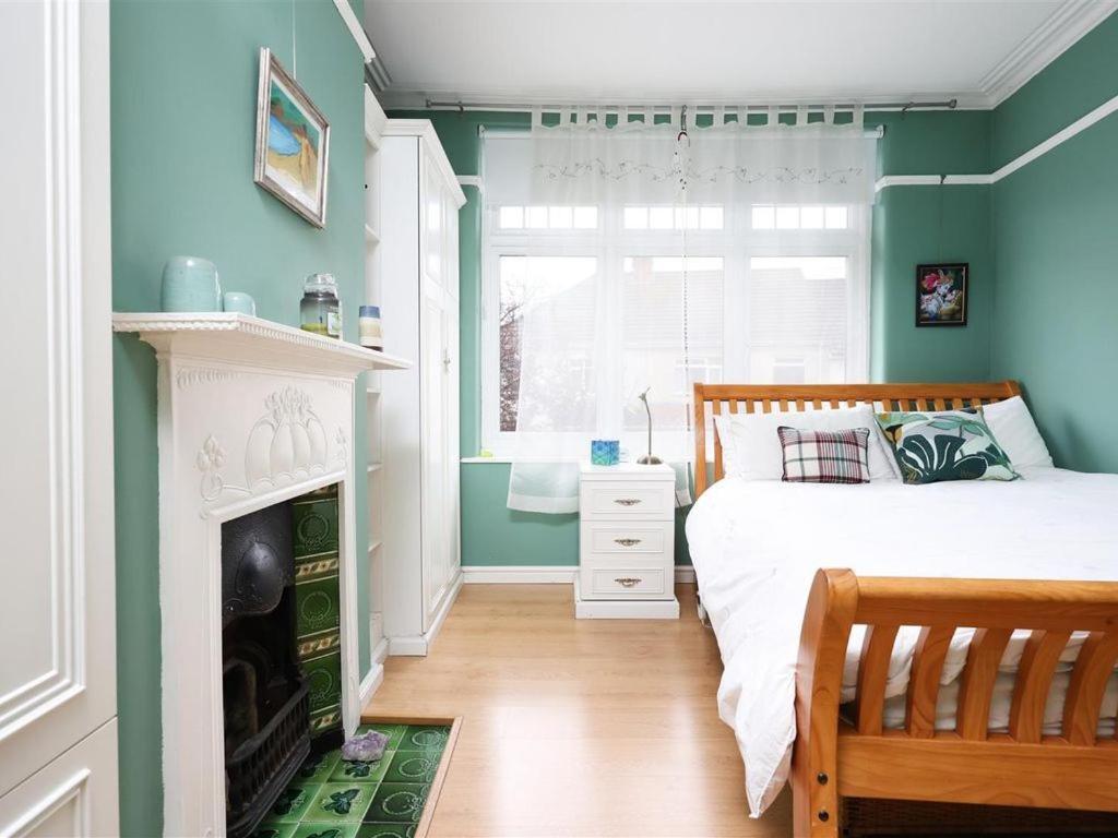 a bedroom with blue walls and a bed and a window at Comfortable Bristol Escape near Gloucester Road in Bristol