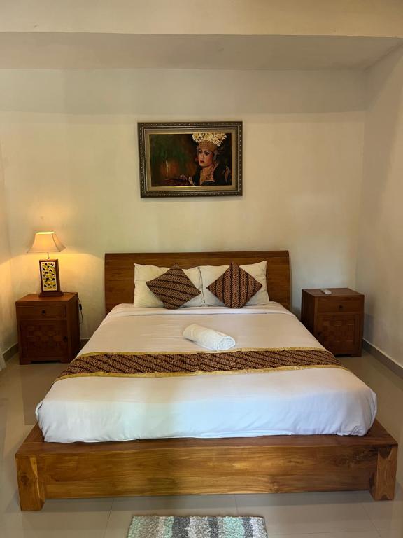 a bedroom with a large bed with white sheets at Villa Miracle Ubud in Ubud