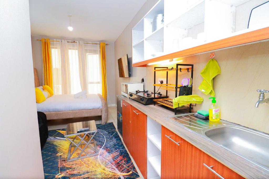 - une cuisine avec évier et un lit dans une chambre dans l'établissement Jay Authentic Homes, à Nairobi