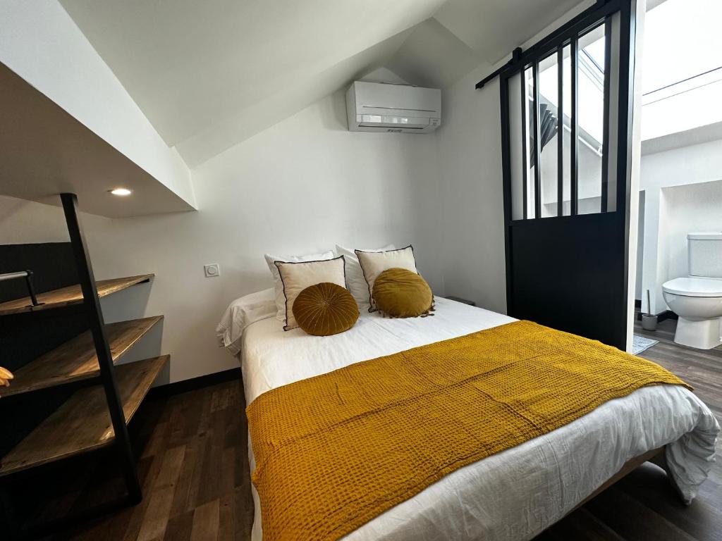 Un dormitorio con una cama con una manta amarilla. en La maison de Nita - chambres d'hôtes en Bergerac