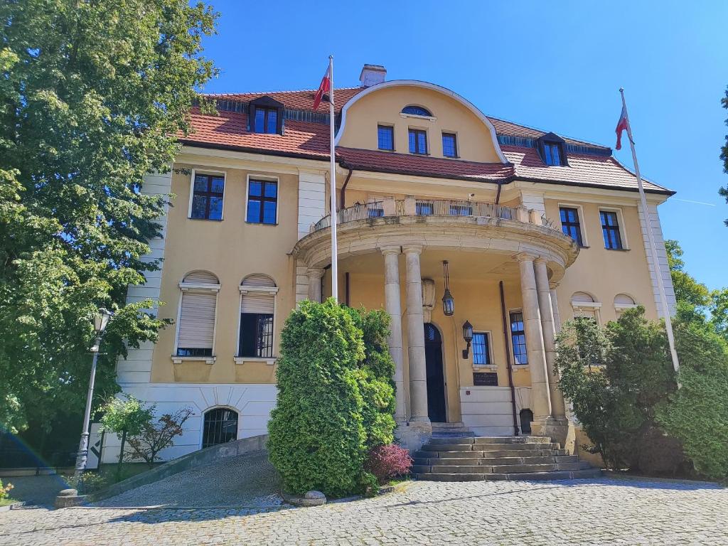 un grande edificio giallo con portico e colonne di Pokój jednoosobowy z prywatną łazienką - Piotrkowska 262-264 pok 302 a Łódź